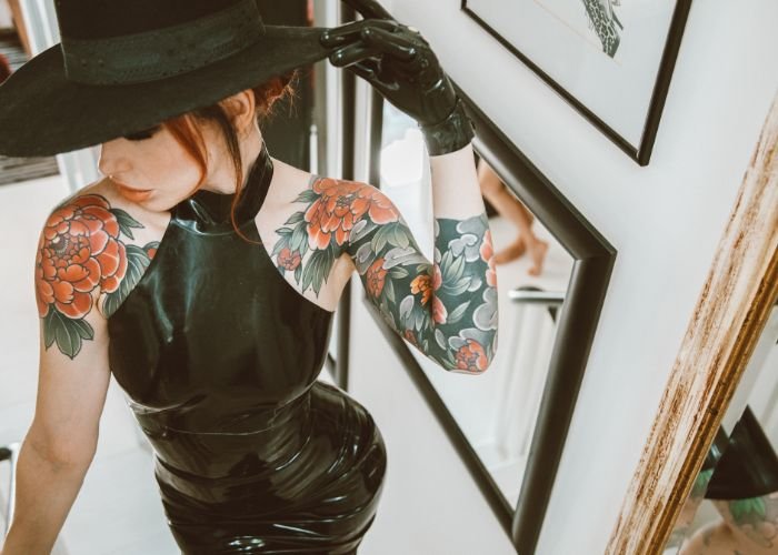 Mistress Adreena in latex looking away.